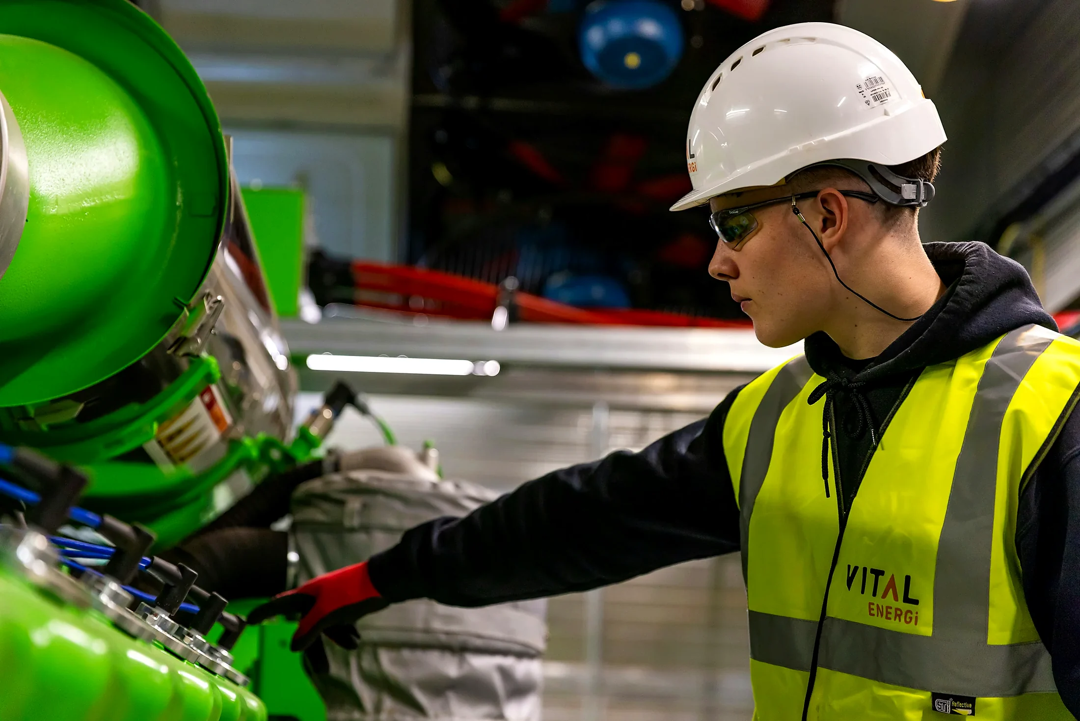 Engineer inspecting and maintaining guarded industrial machinery